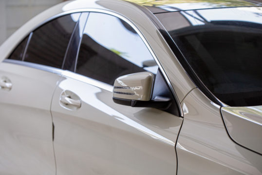side mirror of white car with tinted glass